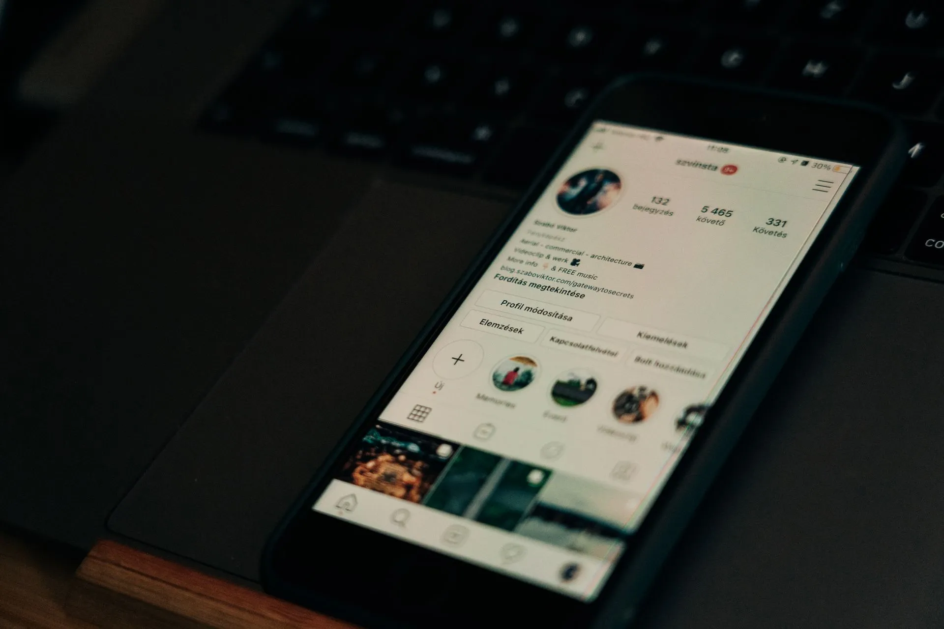 Close-up of smartphone showing a social media profile screen next to a laptop, illustrating Hackers hijack Microsoft's 13-million-follower X account to promote a Clippy crypto token