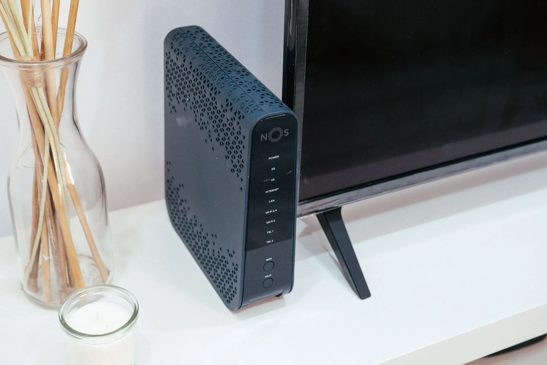 A sleek home technology setup featuring a router, glass decoration, and television, illustrating MikroTik RouterOS flaw rated 9.8 allows root takeover with no login, CISA warns
