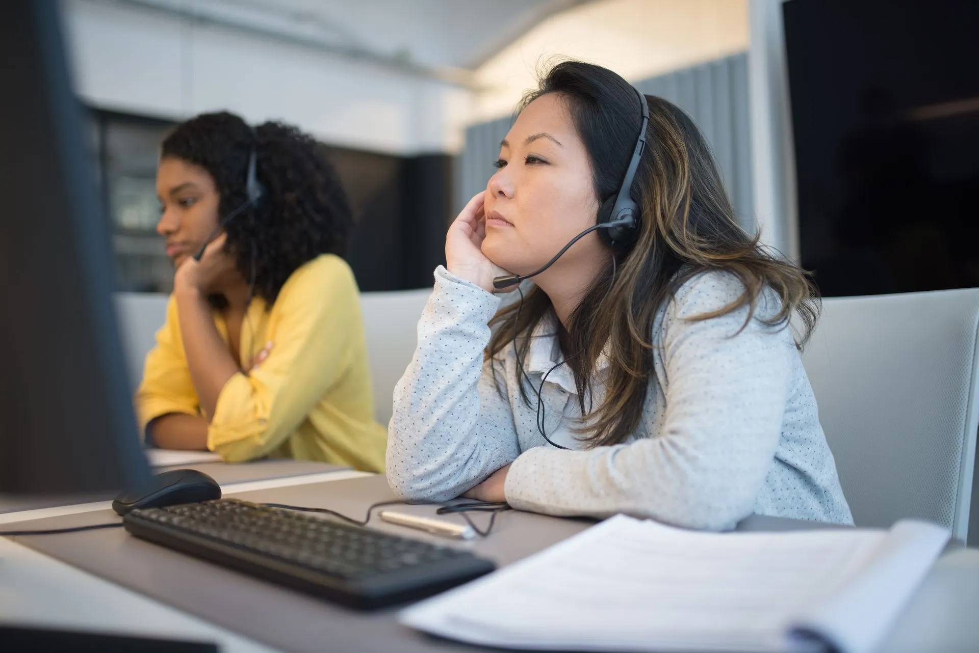 Focused customer support team using headsets at their desks in office environment.