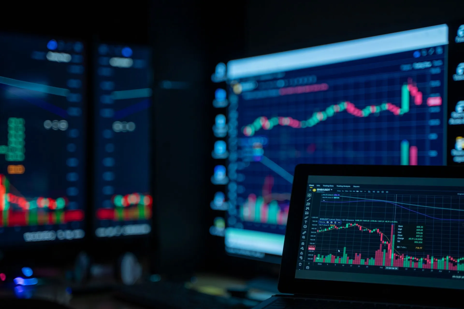 Monitors displaying stock market charts in a dimly lit room, perfect for finance and trading themes, illustrating MoonPay agrees to acquire North Capital, adding SEC-registered