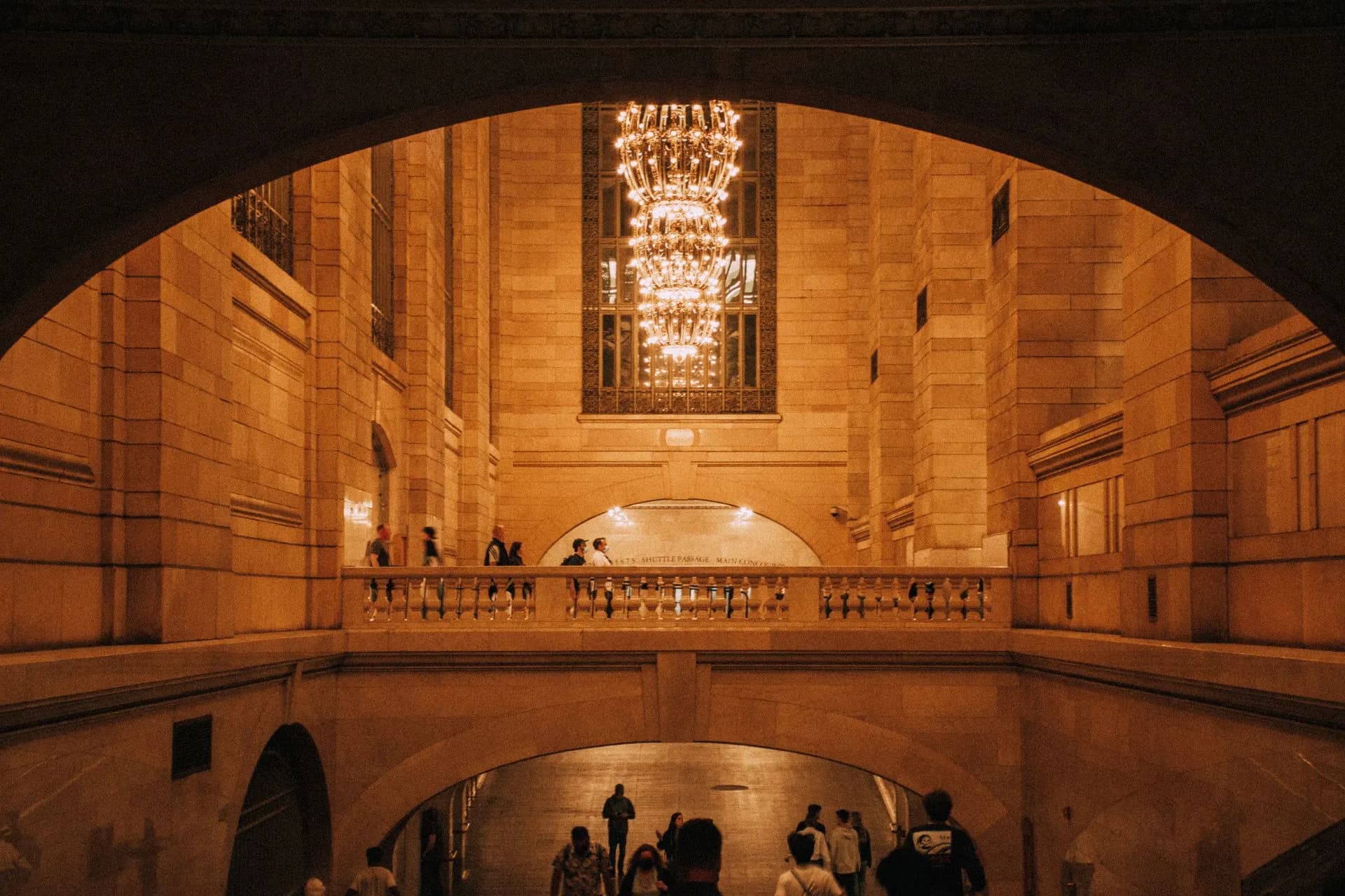 Warmly lit interior of Grand Central Terminal showcasing beautiful chandeliers and stone architecture, illustrating New York City AI regulation hearing