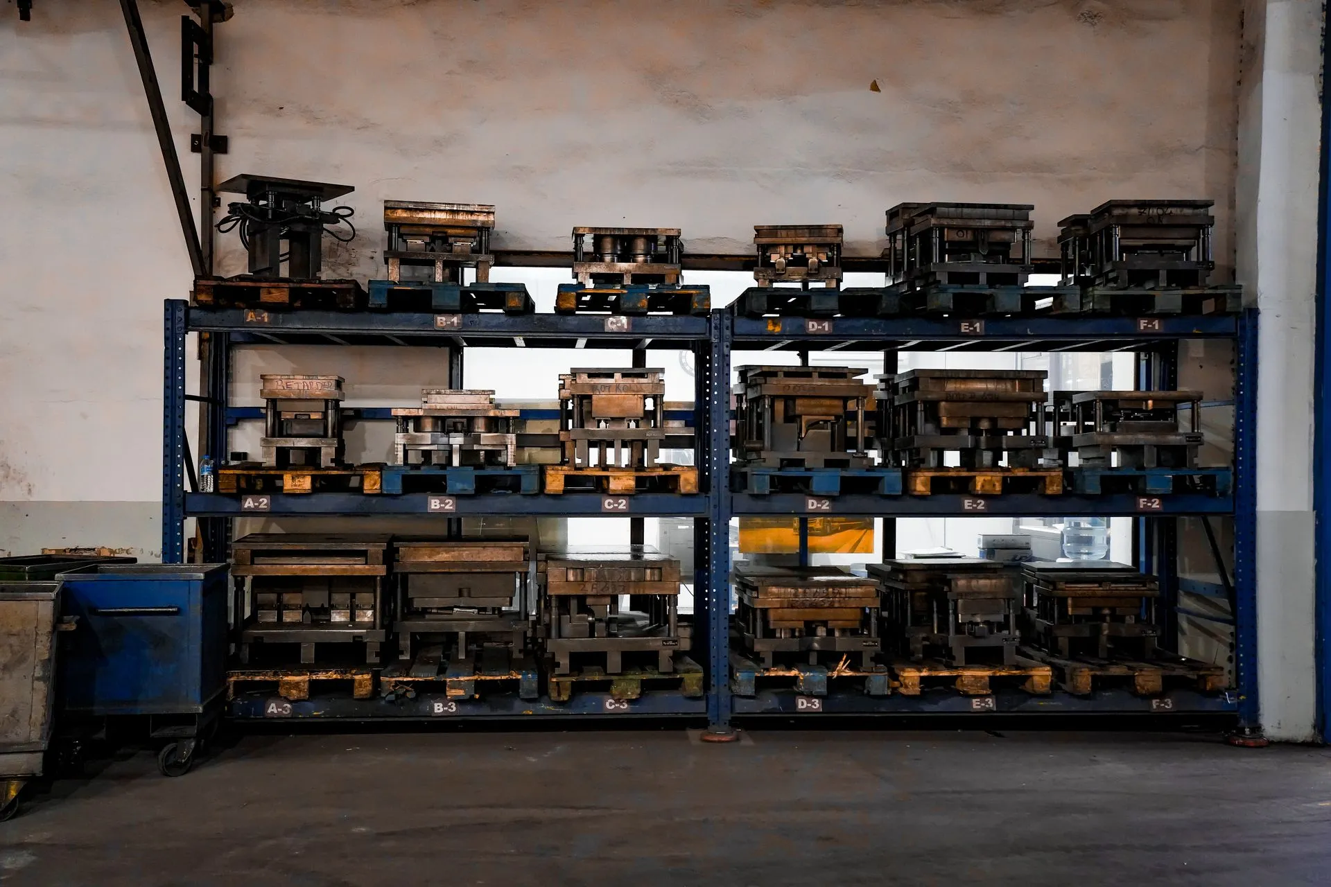 Metal molds neatly arranged on industrial shelving in a warehouse setting, showcasing order and efficiency, illustrating Nvidia commits $1 billion over five years to US science