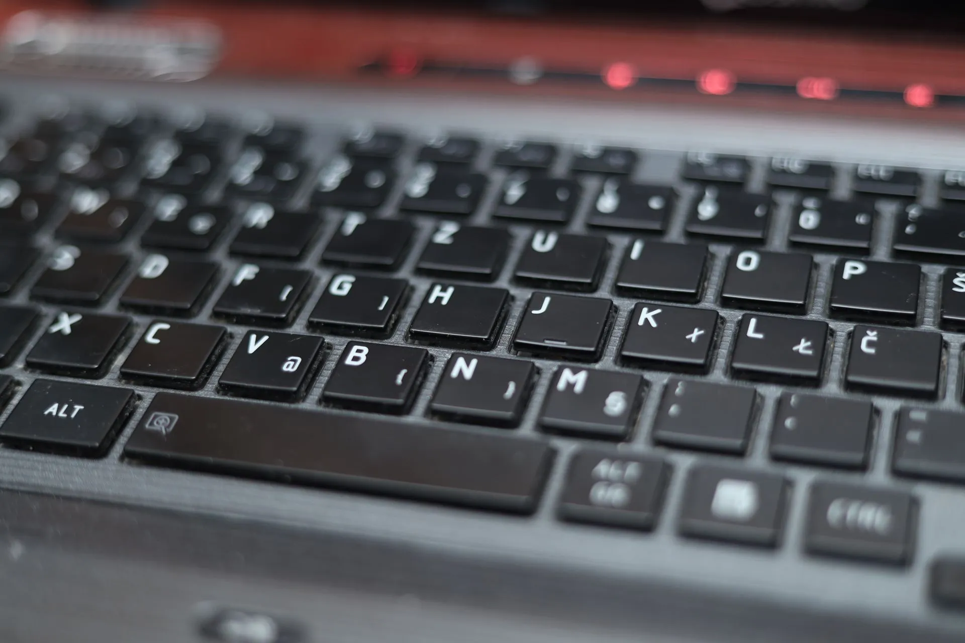Blurred close-up of a laptop keyboard with black keys and symbols, highlighting technology, illustrating OpenAI hires ex-White House cyber official Thomas Lind to lead cyber and