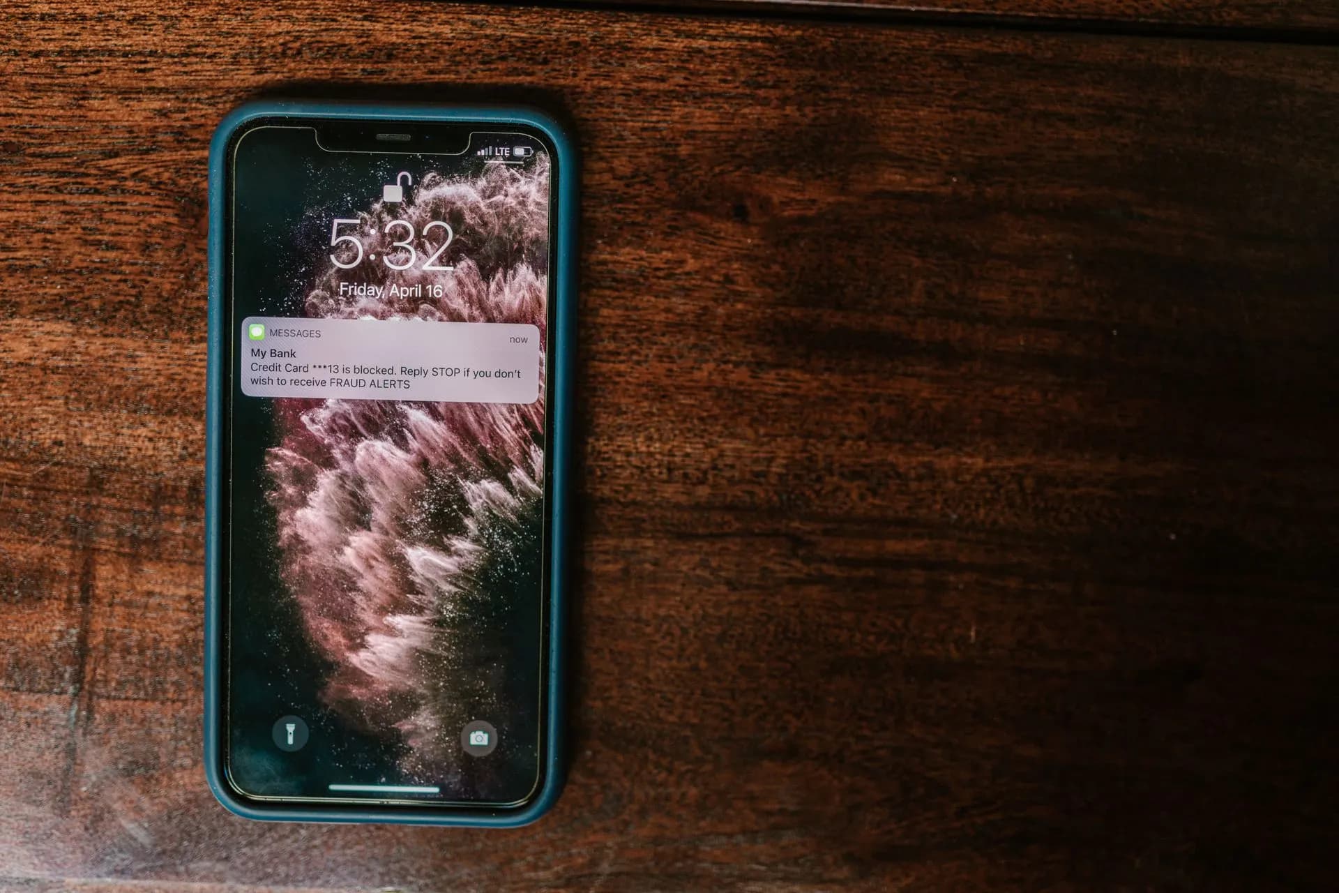 Close-up of smartphone on wooden surface displaying a bank alert message, illustrating OpenAI always-on assistant "o" briefly appears as a $100 ChatGPT Pro plan perk