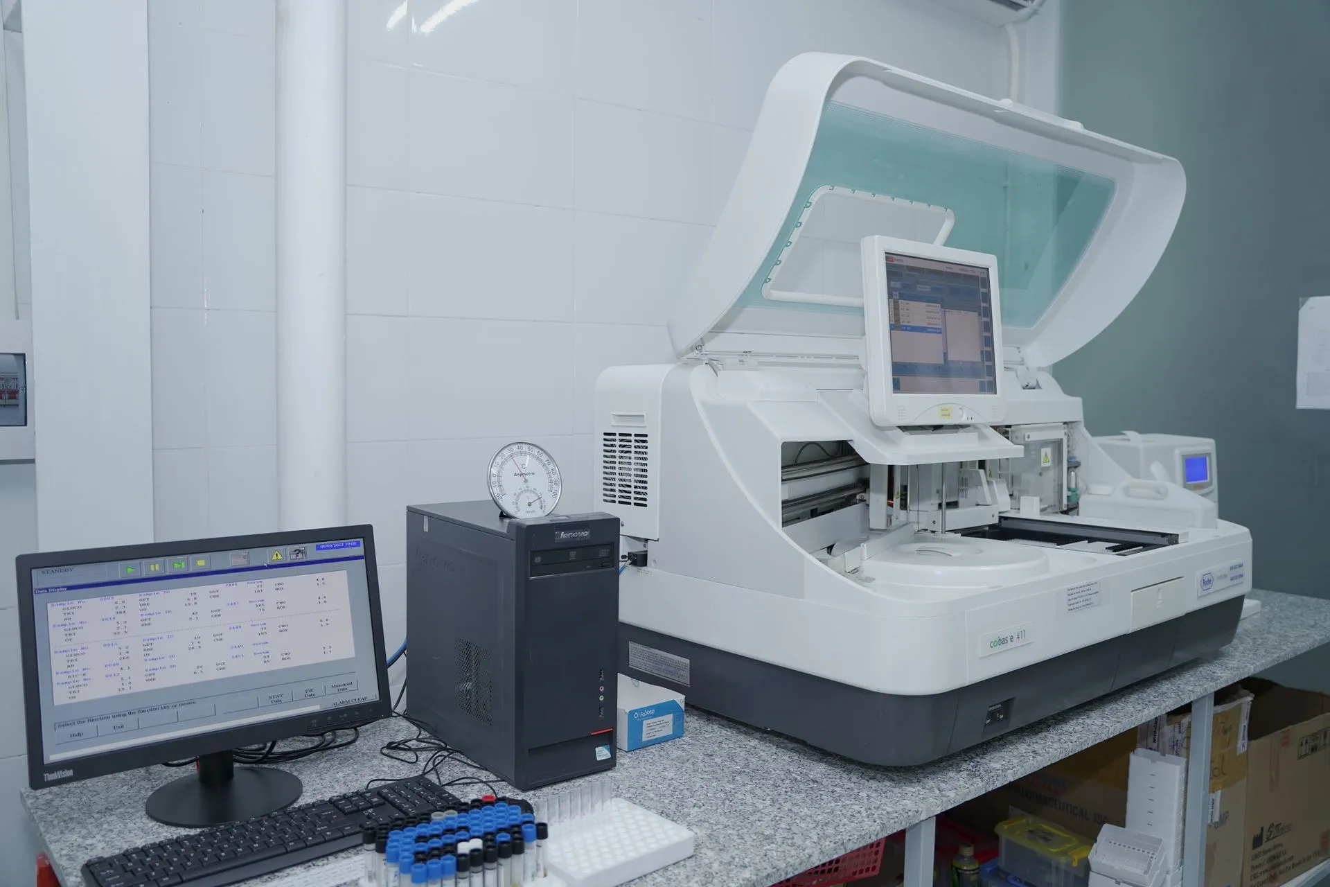 High-tech laboratory equipment with computer system in lab setting, illustrating Palantir NHS contract