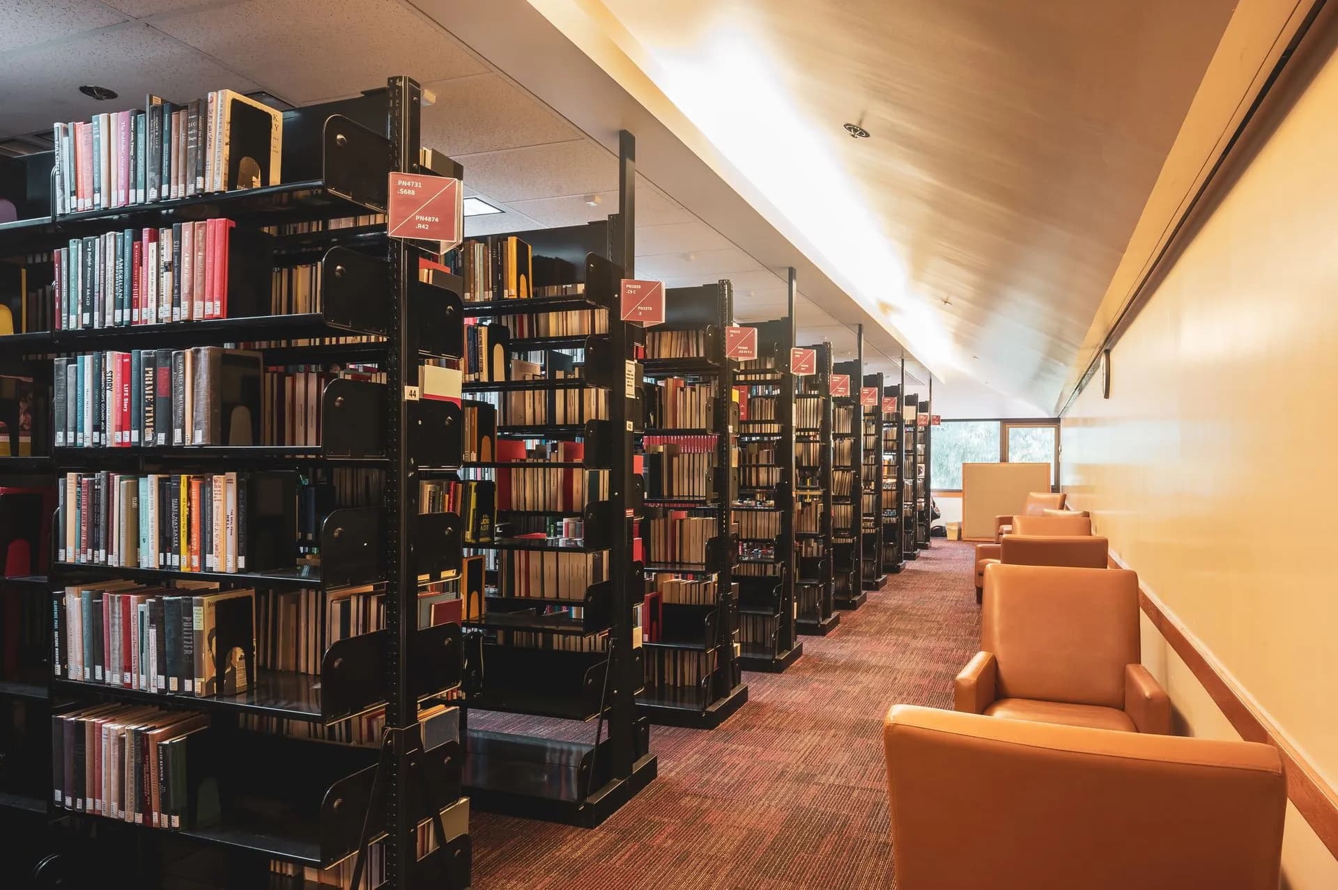 Library interior with bookshelves and armchairs. Ideal for education and reading themes, illustrating Accused Iranian hacker extradited to US as MI5 flags China research espionage at