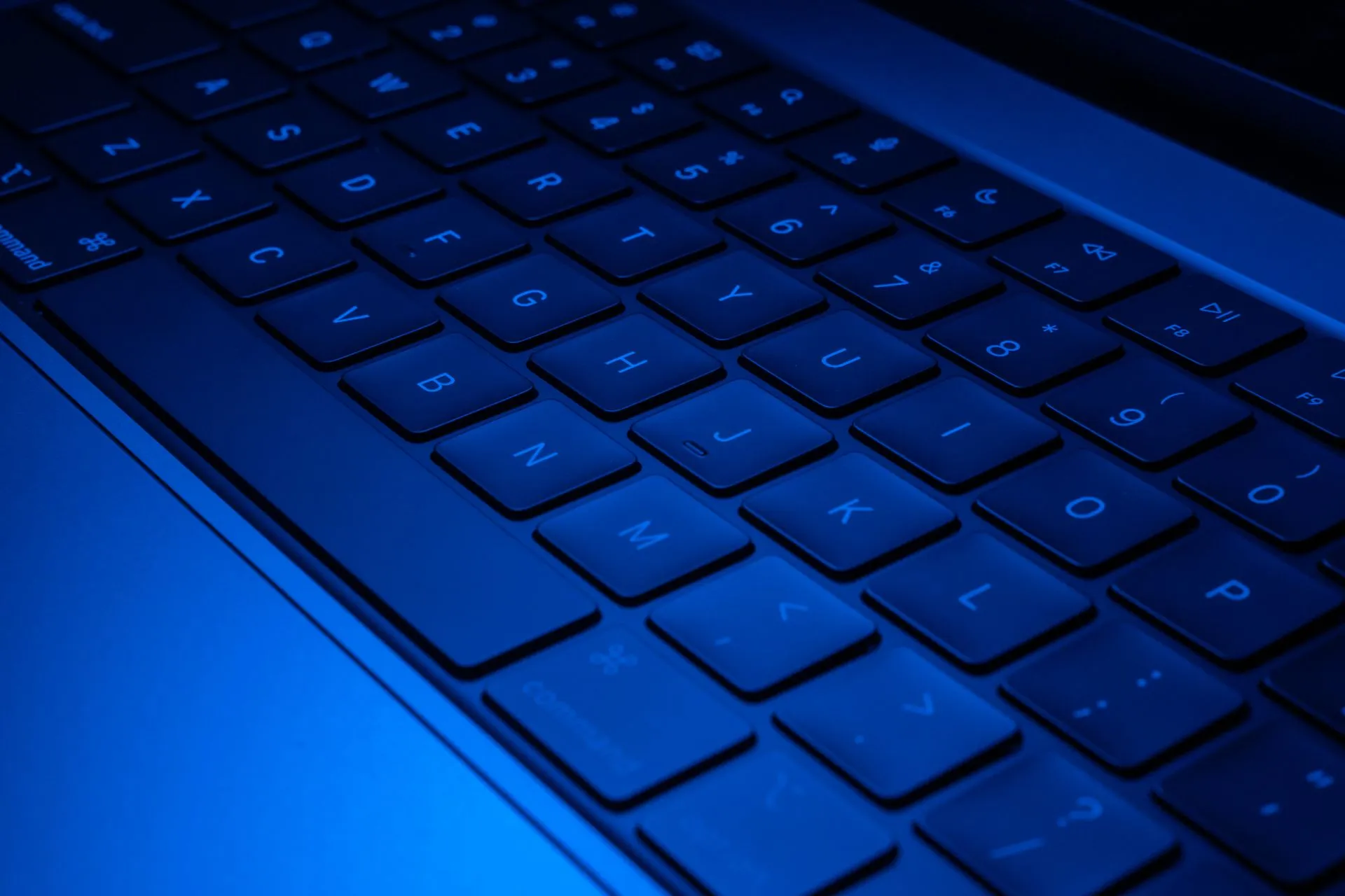 Close-up image of a laptop keyboard illuminated with blue light, showcasing modern technology design, illustrating Rig Security launches with $12 million to catch AI agents acting