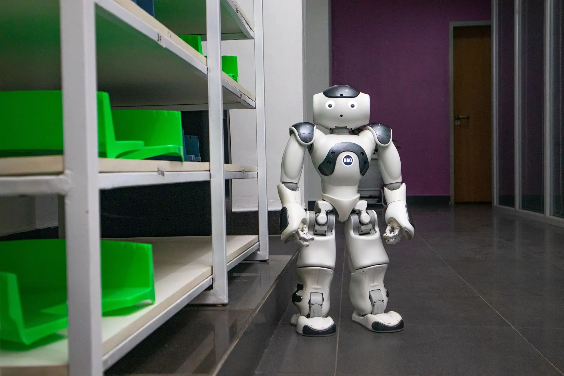 A humanoid robot standing in a modern corridor with shelves, representing futuristic technology, illustrating FORT Robotics' $556.6M SPAC deal, Destro AI and Safeworld rounds put money