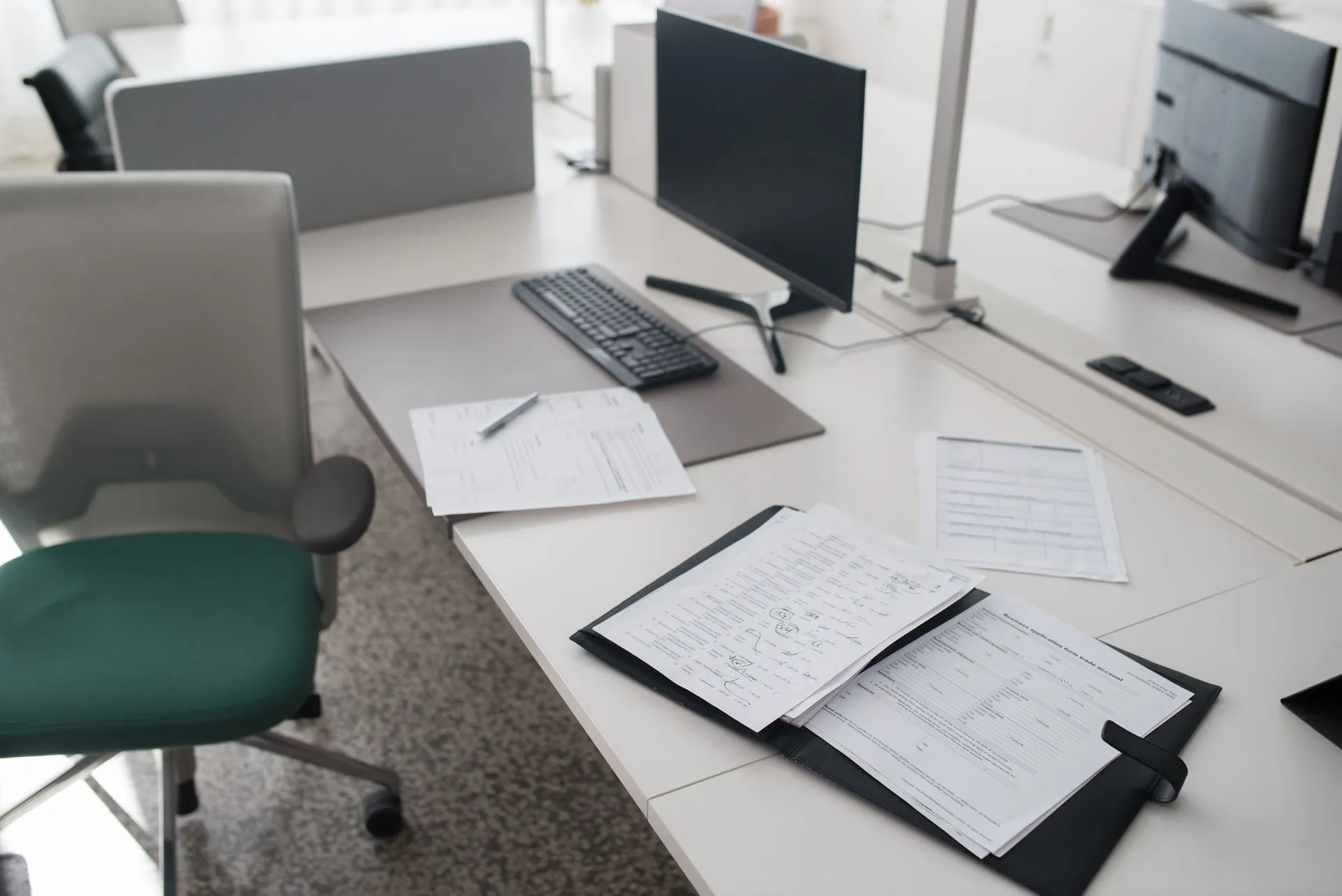 A clean and organized office desk with documents, a computer, and chair in a modern workspace, illustrating SaaSpocalypse lessons
