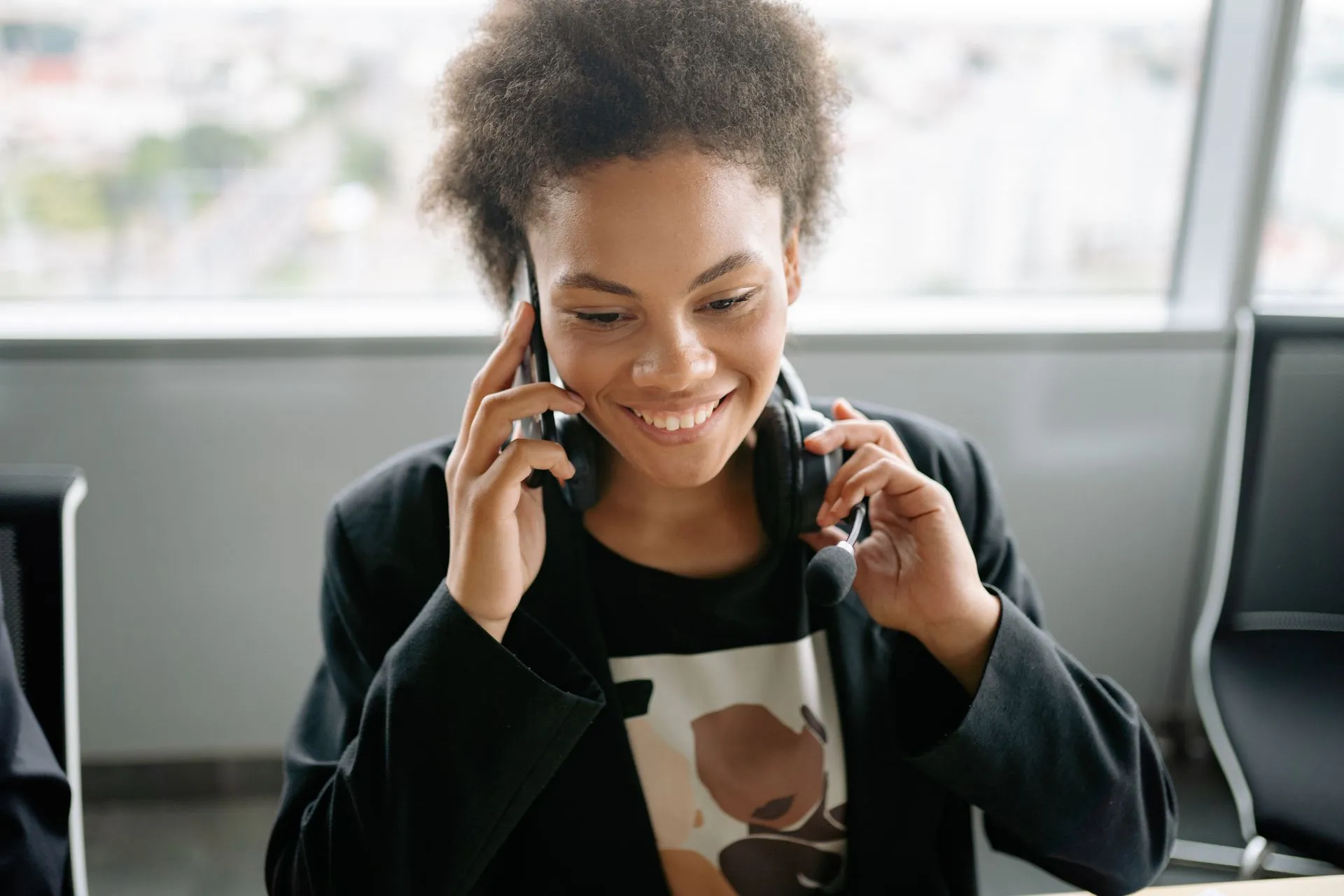 A cheerful call center agent talking on the phone with a headset, illustrating Sangoma acquisition by BRC Group Holdings carries a $204 million enterprise value