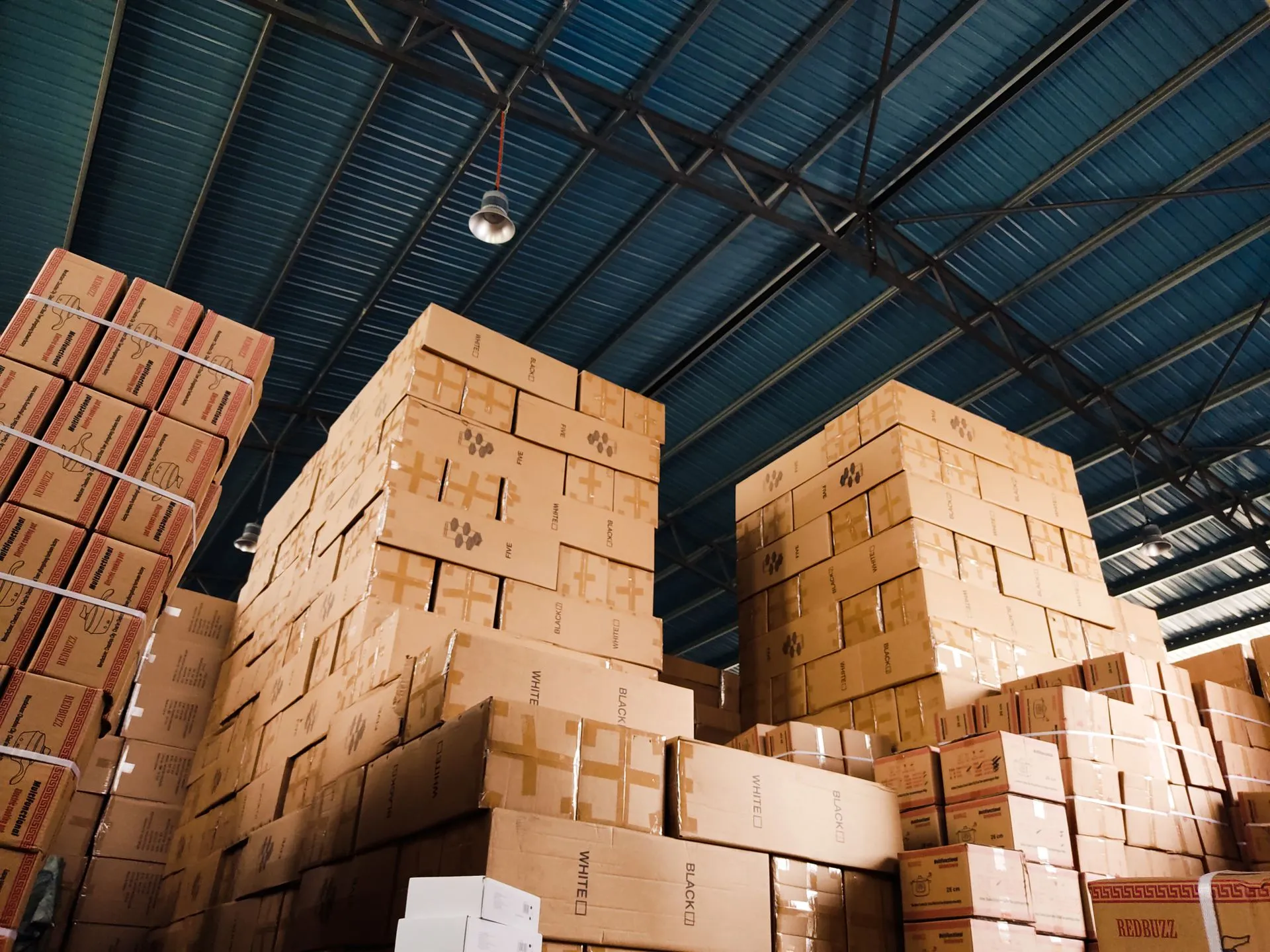 High stacks of cardboard boxes organized in a warehouse with a blue metal ceiling, illustrating Settle credit facility of $240 million expands working capital lending to bigger