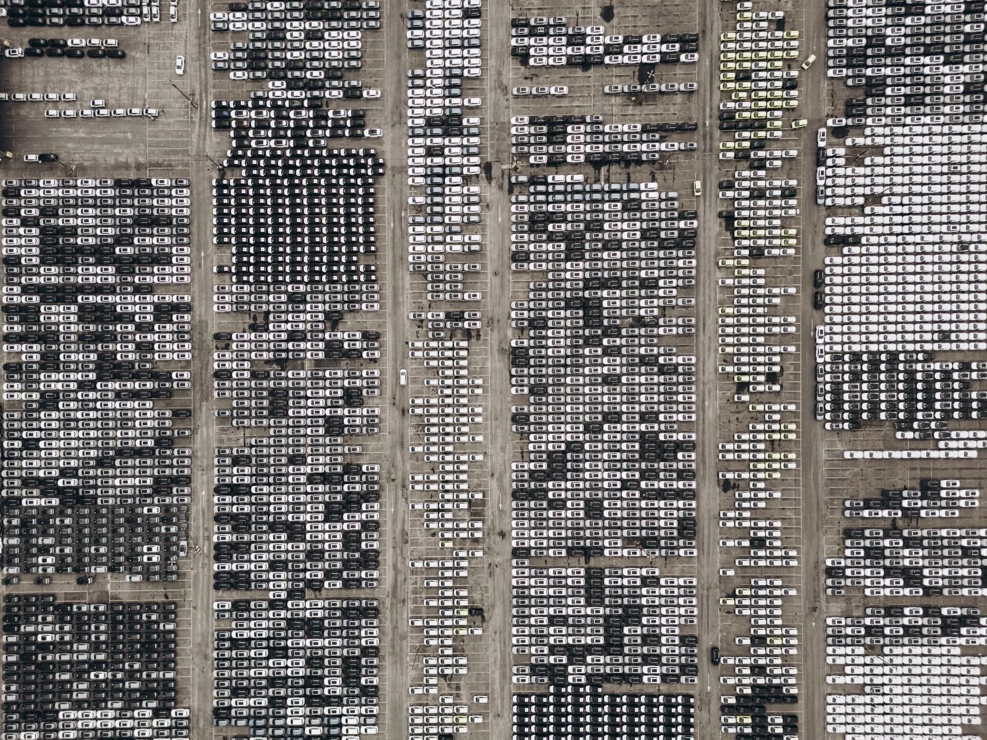 High-angle aerial shot of a massive car parking area, filled with vehicles in Brazil, illustrating Tesla credit lines total $30 billion, but it doesn't plan to tap them in 2026