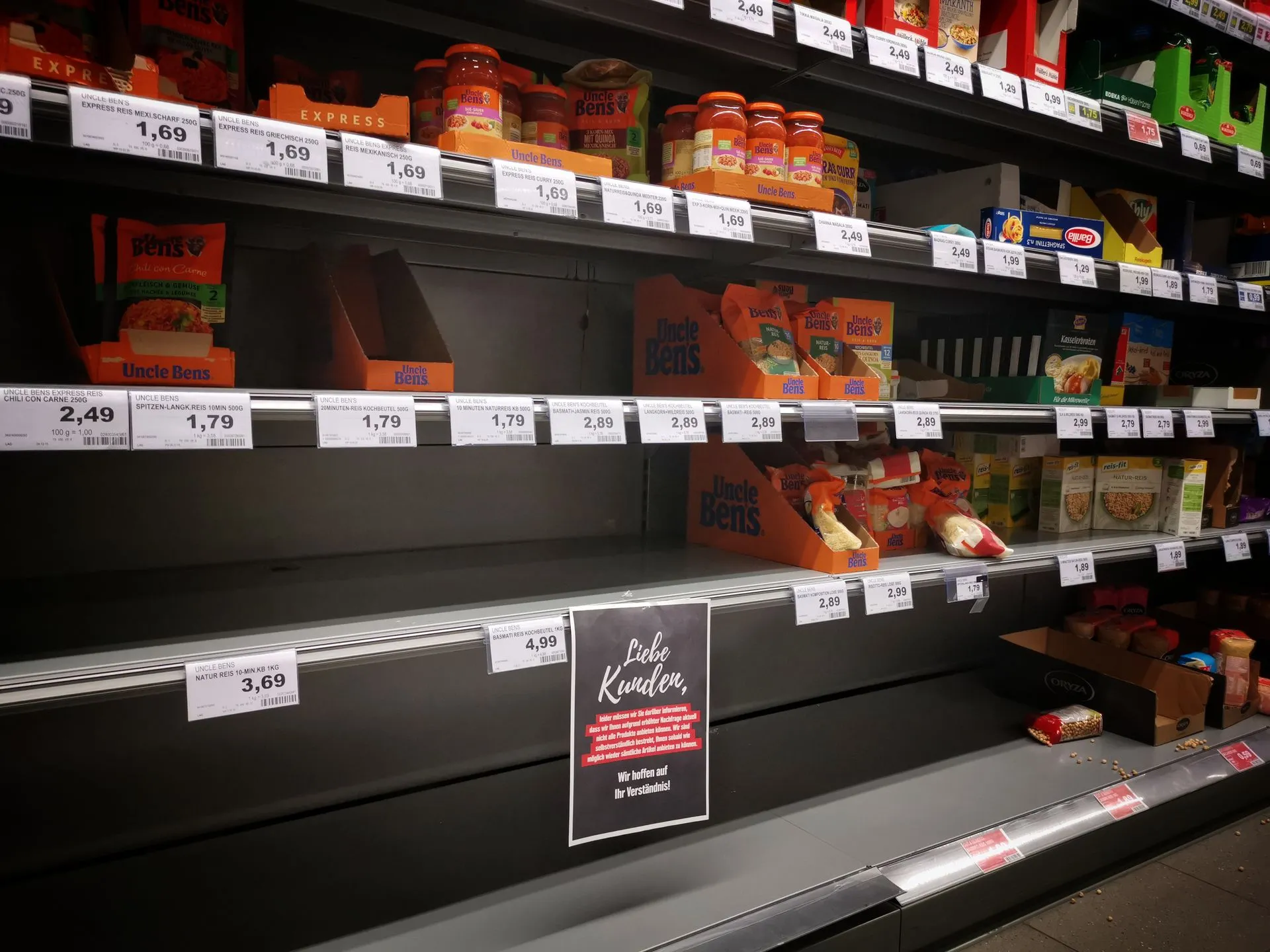 Half empty shelves with assorted products in jars and containers in supermarket during quarantine, illustrating Walmart digital shelf labels