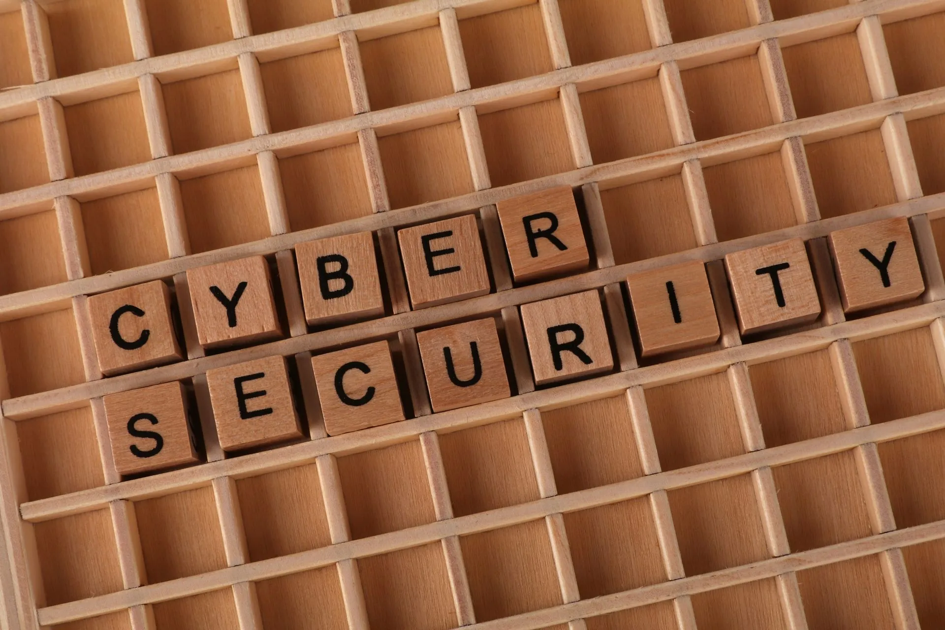 Wooden blocks spelling 'Cyber Security' on a wooden grid background, illustrating WatchGuard Fireware OS vulnerability rated 9.2 leads 15 firewall bug fixes