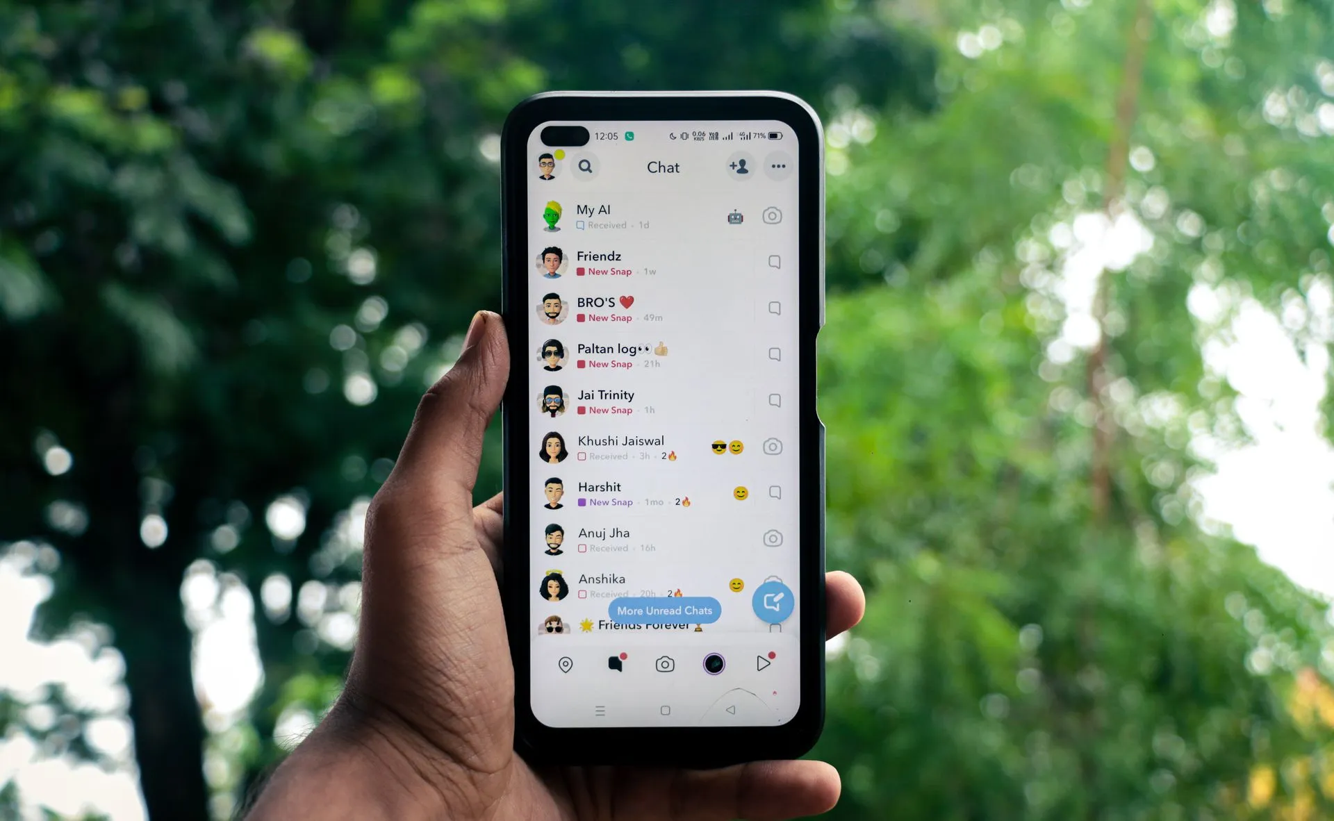 A hand holding a smartphone displaying a chat application outdoors against a green background, illustrating WhatsApp investment scams took $15M+ with fake AI bots and forged SEC
