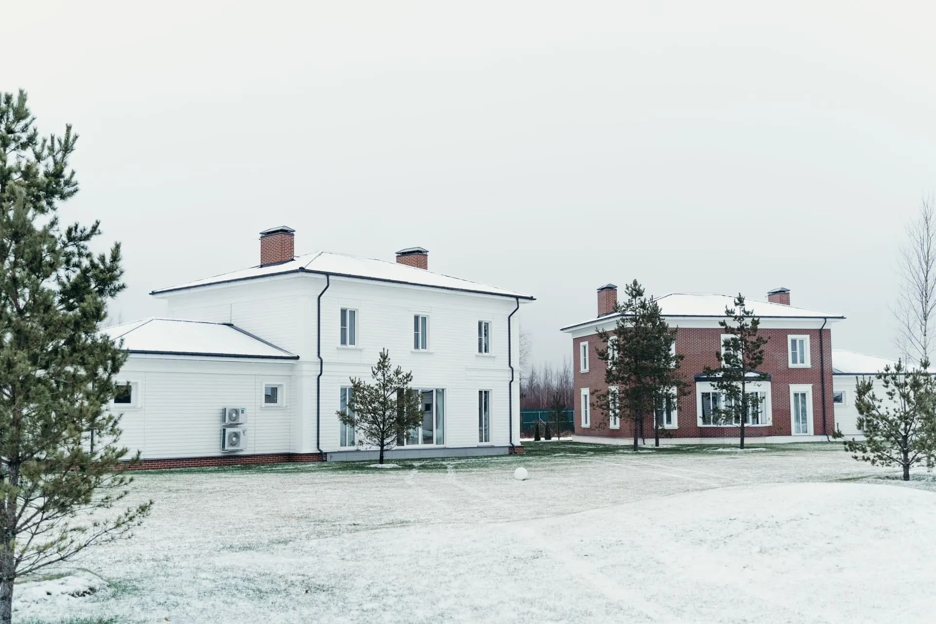 Two modern houses in a snowy winter scene with pine trees, illustrating White House Super Intelligence accord