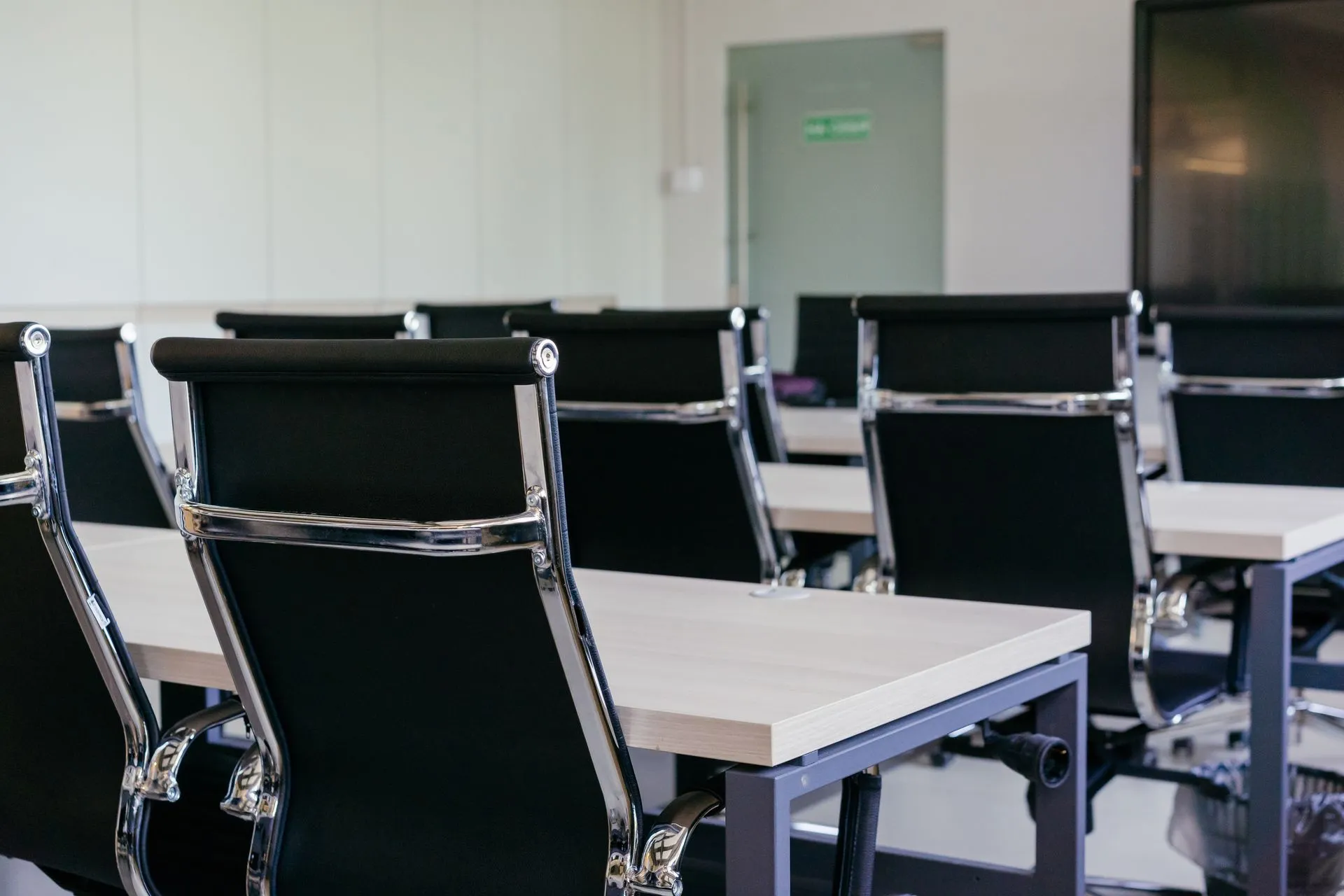 Sleek modern conference room with black chairs and white desks, suitable for business meetings, illustrating Workday layoffs hit 2.5% of staff, mostly in product and tech, costing up