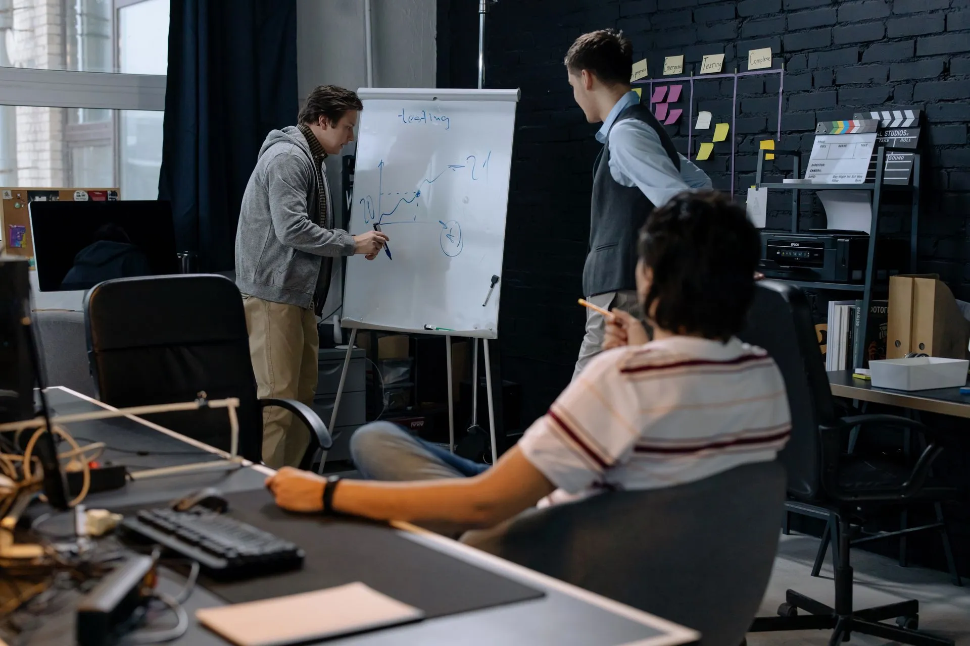 Business team in a modern office brainstorming ideas on a whiteboard. Engaged discussion and planning, illustrating Y Combinator names Vivian Midha Shen and Raphael Schaad general