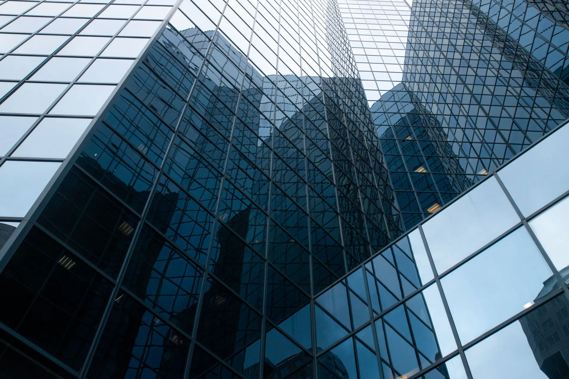 Low-angle view of a modern glass skyscraper with reflective windows capturing urban architecture, illustrating Yandex data center in Russia halted after reported Ukrainian drone strike