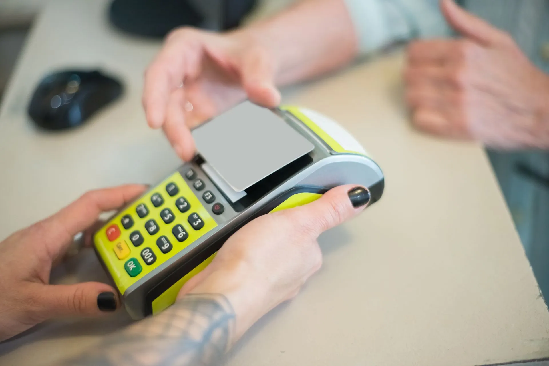 Hands engaging in a secure card transaction with a payment terminal, capturing the essence of modern business transactions, illustrating Yuno brings multi-acquirer routing to in-store payments