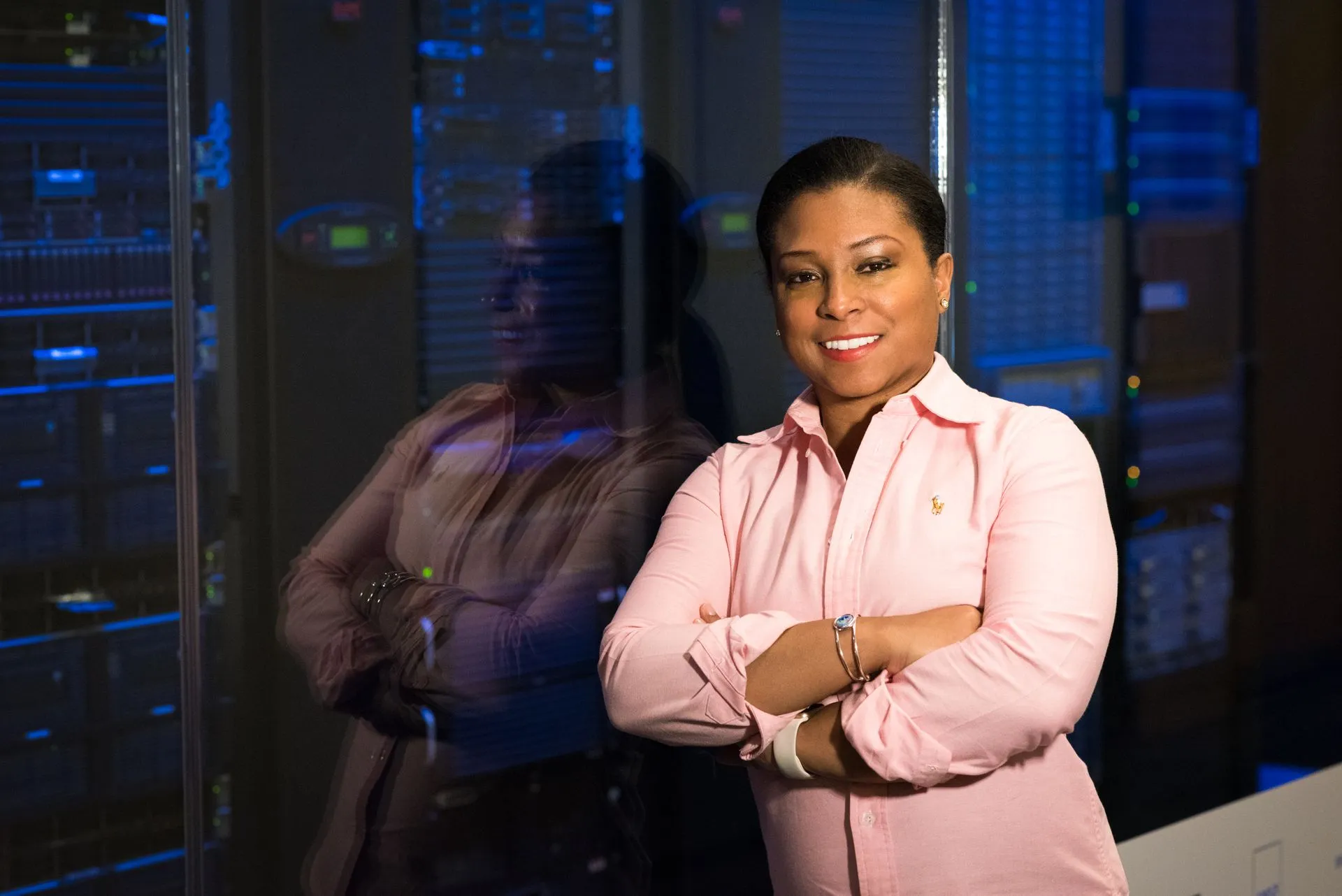Smiling IT professional with crossed arms in a server room, reflecting her expertise, illustrating Zimbra flaw CVE-2026-73570 was exploited before disclosure through crafted emails