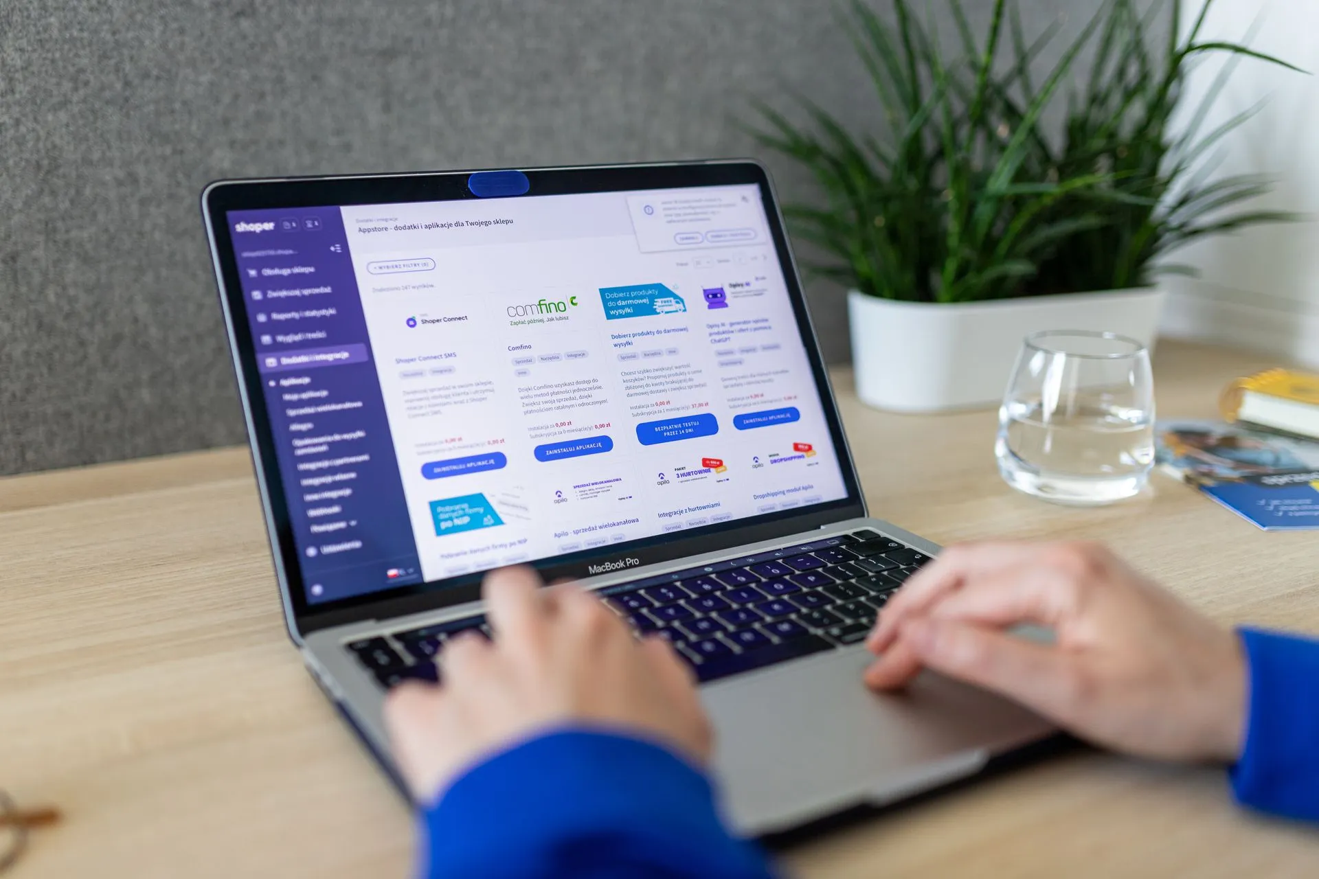 Close-up of hands on a laptop browsing an e-commerce site in a modern office, illustrating ZoomInfo DoubleO.ai acquisition brings Agent Teams to run multi-step sales plays
