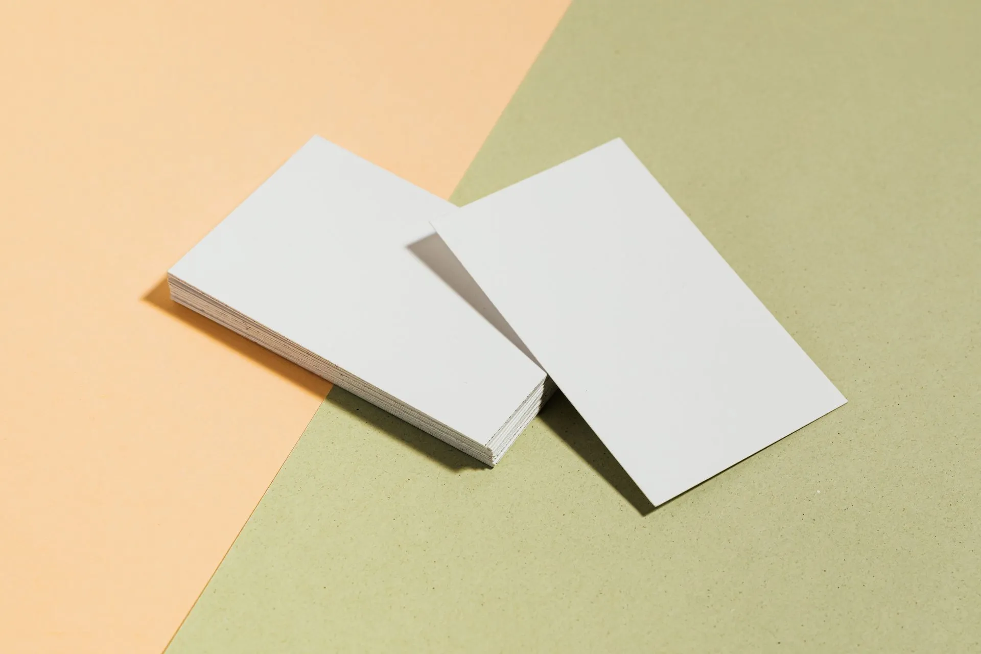Stack of blank white business cards on pastel surface offering copy space for design, illustrating ZoomInfo Superhuman Go connector puts 500 million contacts inside an AI assistant