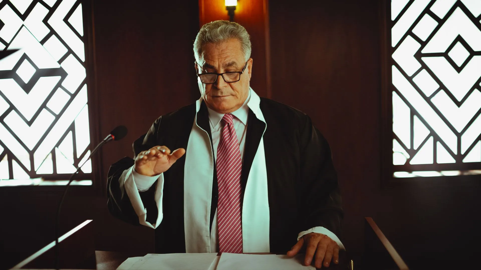 Mature male judge in a courtroom taking an oath, Baghdad, Iraq, illustrating Jury orders Apple to pay $5.7 billion in Taptic Engine patent case