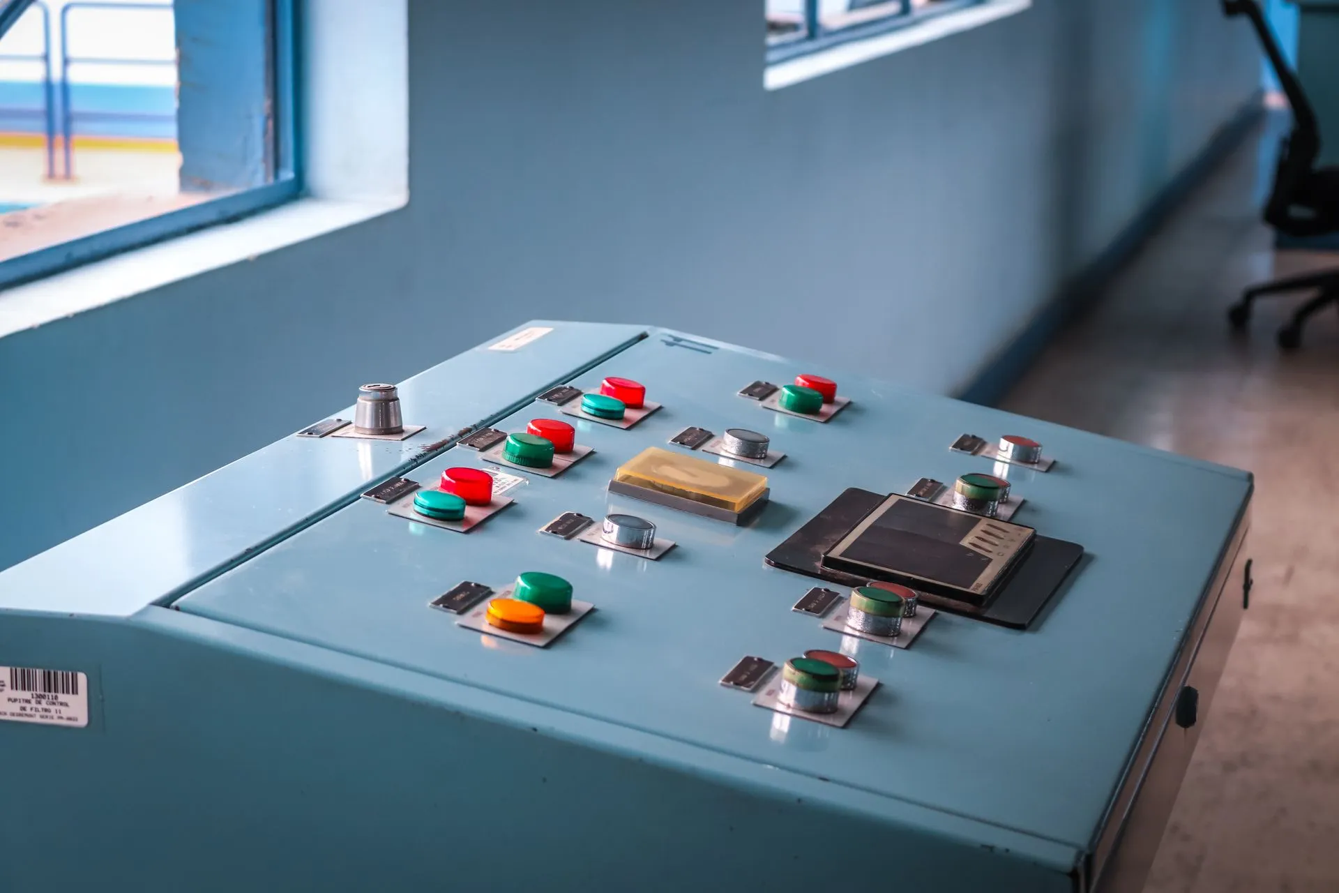Close-up of an industrial control panel with colorful buttons in a factory setting, illustrating Enterprise AI agent reliability