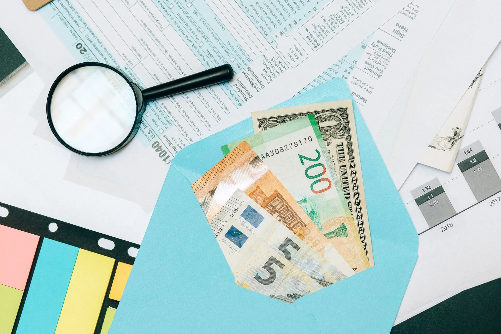 Close-up of tax documents and mixed currency in a blue envelope with a magnifying glass, perfect for financial analysis, illustrating Stuut raises $52.5 million to put AI agents on